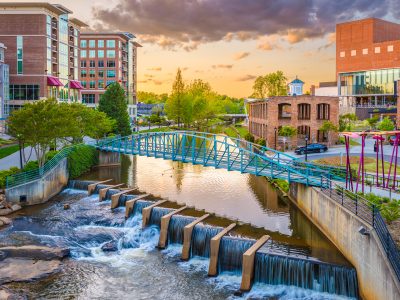 Greenville, South Carolina, USA downtown cityscape on the Reedy River at dusk.